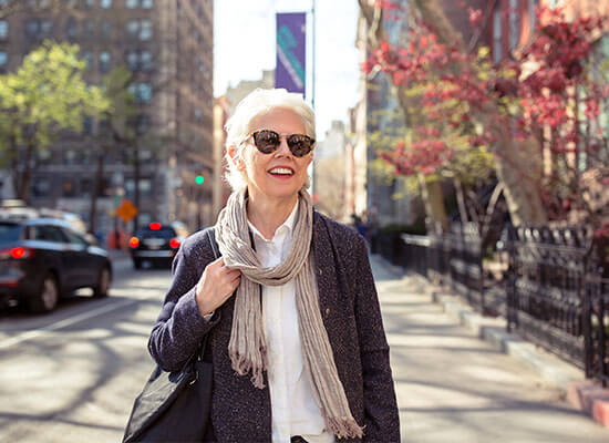 Woman with sunglasses on walking down a New York street during fall.